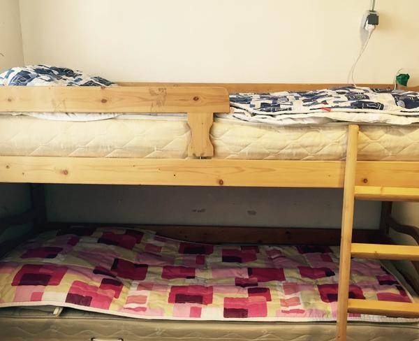 تخت دو طبقه چوبی تمیز همراه با تشک